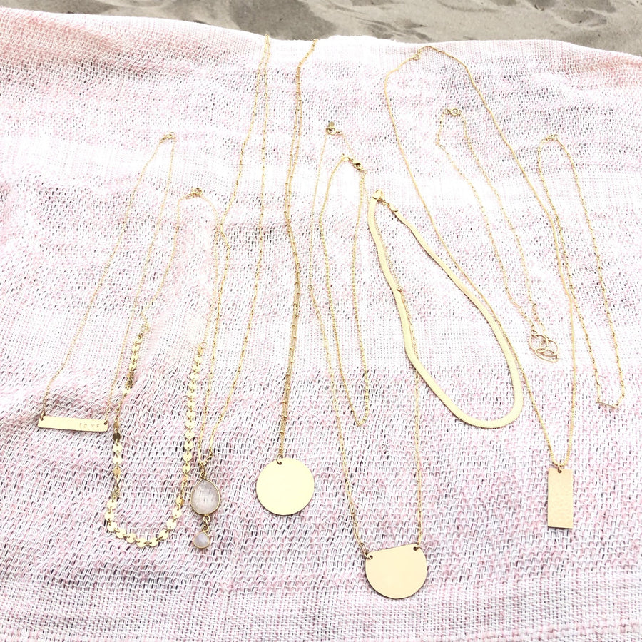 Megen Gabrielle Jewelry | 14K gold fill shine half moon necklace displayed with other 14K gold fill necklaces