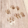 Megen Gabrielle Jewelry | Huggie dangle earrings. huggie earrings. minimal huggie earrings. huggie earrings with charms. 14k gold fill huggie earrings. triangle charm huggie earrings, dagger huggie earrings. Leaf charm huggie earrings, petal charm huggie earrings. square charm huggie earrings, hammered square charm earrings. circle charm huggie earrings, curcle dangle charm huggie earrings. 14k gold fill earrings. huggie hoop earrings, 14k gold fill huggie hoop earrings.