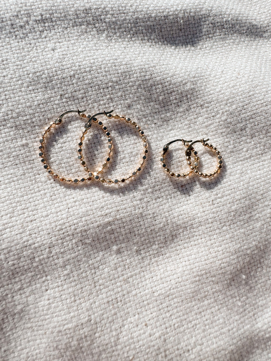 Megen Gabrielle Jewelry | huggie hoops. huggie earrings. minimal huggie earrings. huggie earrings with charms. 14k gold fill huggie earrings. CZ diamond huggies, diamond hoops, dot huggies, beaded hoop, beaded tiny hoop, tiny hoops, gold hoops, circle charm huggie earrings, circle dangle charm huggie earrings. 14k gold fill earrings. huggie hoop earrings, 14k gol