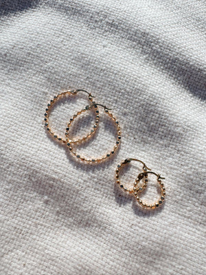 Megen Gabrielle Jewelry | huggie hoops. huggie earrings. minimal huggie earrings. huggie earrings with charms. 14k gold fill huggie earrings. CZ diamond huggies, diamond hoops, dot huggies, beaded hoop, beaded tiny hoop, tiny hoops, gold hoops, circle charm huggie earrings, circle dangle charm huggie earrings. 14k gold fill earrings. huggie hoop earrings, 14k gol
