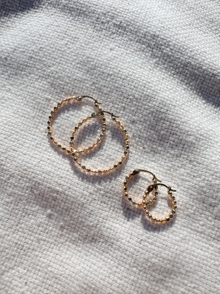 Megen Gabrielle Jewelry | huggie hoops. huggie earrings. minimal huggie earrings. huggie earrings with charms. 14k gold fill huggie earrings. CZ diamond huggies, diamond hoops, dot huggies, beaded hoop, beaded tiny hoop, tiny hoops, gold hoops, circle charm huggie earrings, circle dangle charm huggie earrings. 14k gold fill earrings. huggie hoop earrings, 14k gol