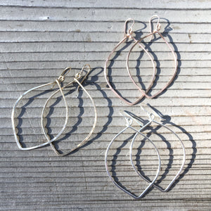 Megen Gabrielle Jewelry | V-shaped oval hooped earrings. V shaped hoop earrings displayed with other jewelry