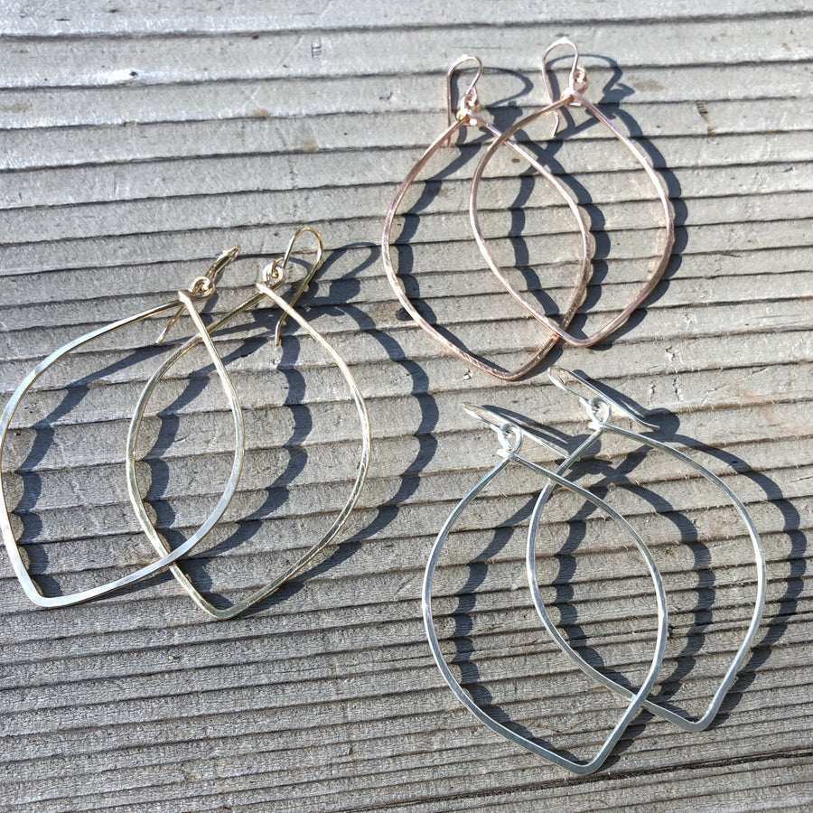 Megen Gabrielle Jewelry | V-shaped oval hooped earrings. V shaped hoop earrings displayed with other jewelry