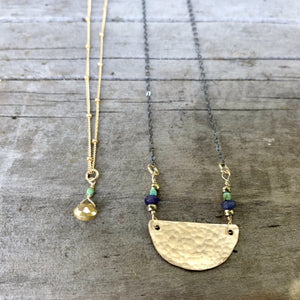 Megen Gabrielle Jewelry | The Rise Mixed Metal Necklace. Half moon shaped charm necklace. Oxidized metal and 14k gold fill combo with light green, dark blue, and gold bead accents. 