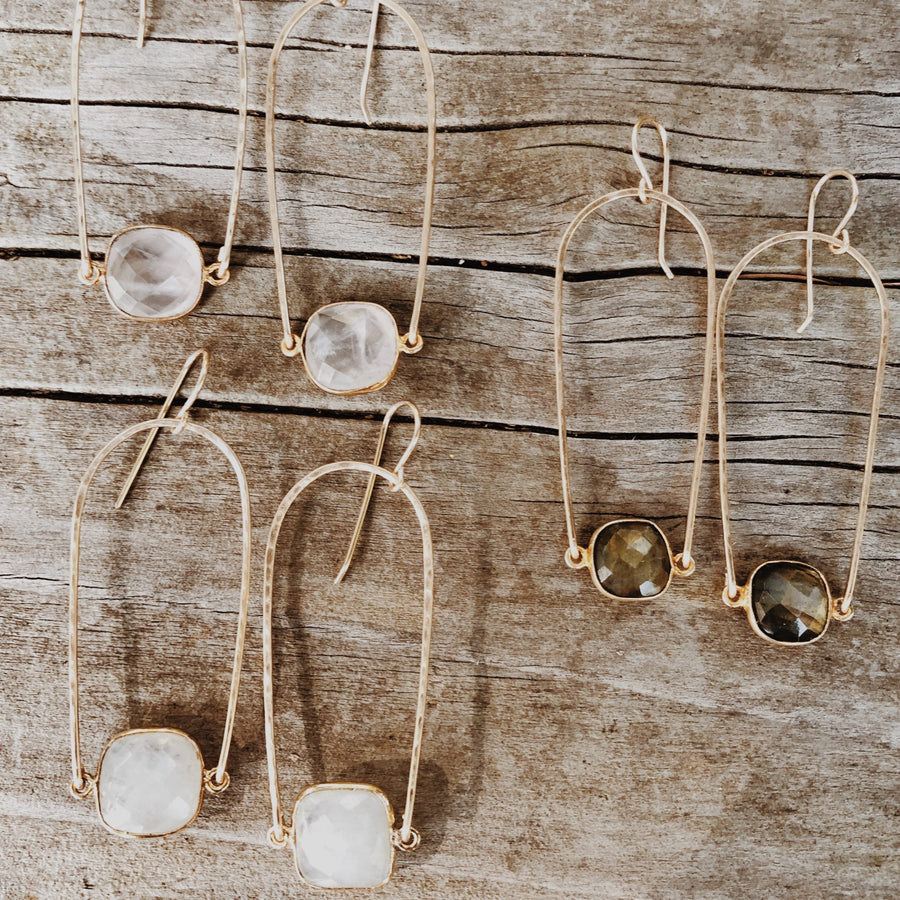 Megen Gabrielle Jewelry | Rainbow gemstone hoop earring. U- shaped (rainbow) earring hoop with gemstone mounted between. In the photo: 14K gold fill and 3 pairs of earrings, rose quartz, labradorite, and moonstone. 